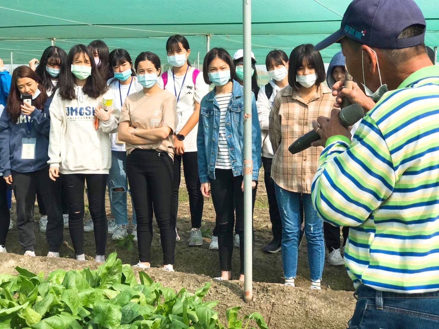 教師向警女學生講解農作物採收過程